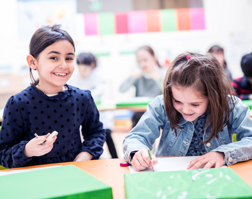 Deux jeunes étudiantes prennent des notes pendant un cours bilingue dans l'école privée de Paris