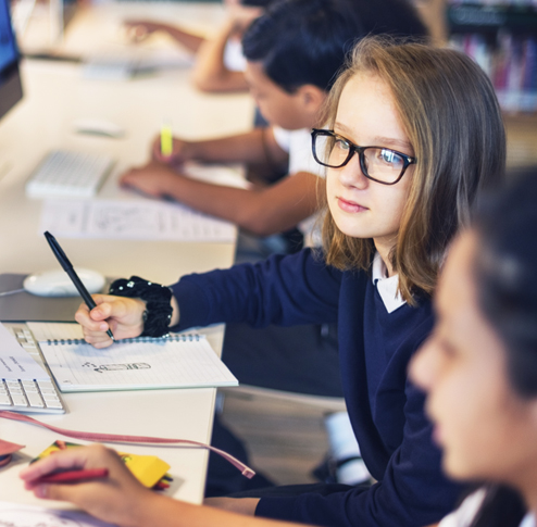 Une collégienne regarde l'écran d'ordinateur pendant un cours bilingue
