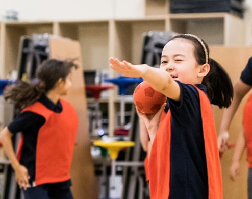 A girl is throwing a ball at the bilingual school of Paris