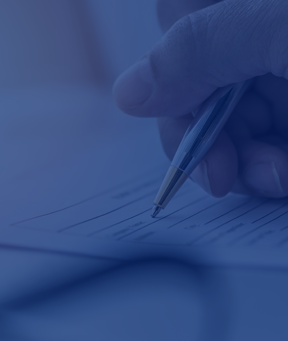 A person filling out a form with a pen for a bilingual school