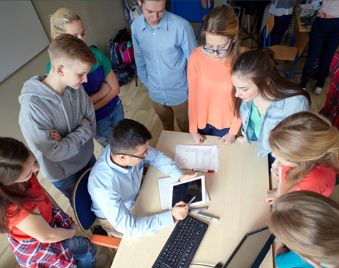 Students gather around their teacher at the BISP middle school