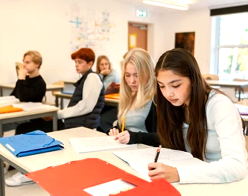 Des jeunes étudiants prennent des notes pendant un cours bilingue dans le lycée privée de Paris